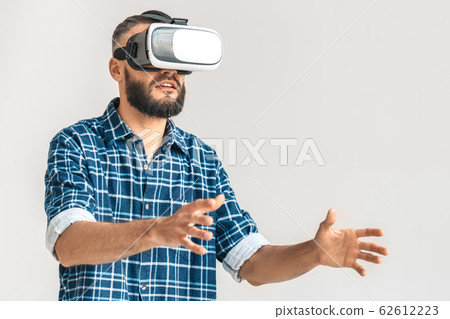 Freestyle. Guy wearing vr headset in checkered shirt standing isolated on white playing game excited 62612223