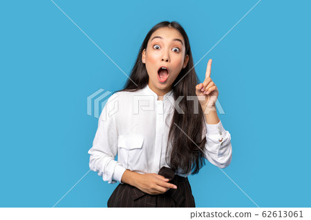 Freestyle. Young woman wearing shirt and skirt standing isolated on blue finger up mouth opened surprised with creative idea Freestyle. Young woman wearing shirt and skirt standing isolated on blue finger up mouth opened surprised with creative idea 62613061