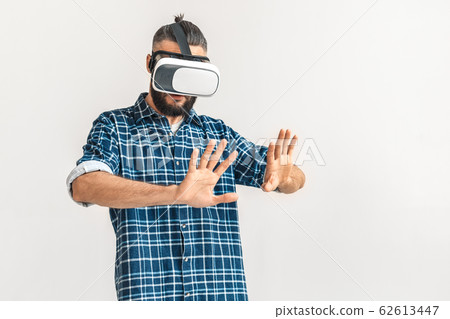 Freestyle. Guy wearing vr headset in checkered shirt standing isolated on white watching video touching space curious 62613447