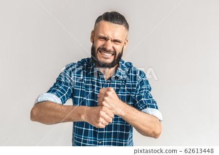 Freestyle. Guy in checkered shirt standing isolated on white making fists strangling gesture frowning showing teeth furious Freestyle. Guy in checkered shirt standing isolated on white making fists strangling gesture frowning showing teeth furious 62613448