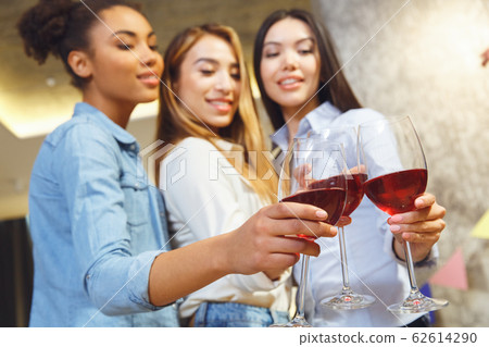 Group of friends having party indoors fun together wine glasses close-up 62614290