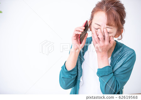 Mature woman calling by smartphone Mature woman calling by smartphone 62619568