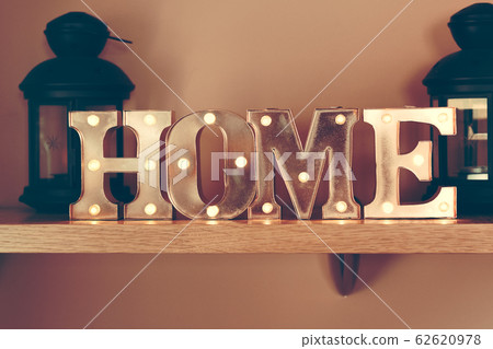 Idea of interior decoration with metal illuminated letters making home word 62620978