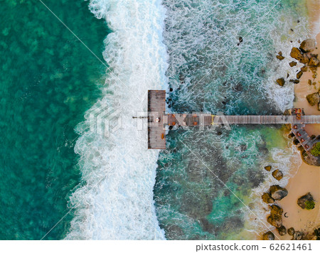 Aerial top view of dock over tropical blue water and sand beach 62621461