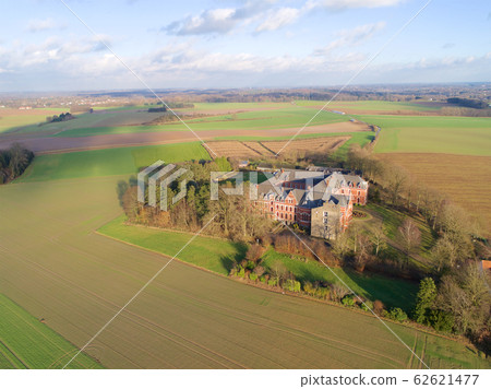Aerial view of little farm castle surrounded by agriculture farmland et small forest 62621477