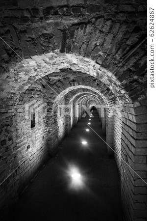 Brick tunnel archway made of red bricks as a passage between the two wings of a medieval castle. Granite stone an brick built Interior corridor way to bastions Brick tunnel archway made of red bricks as a passage between the two wings of a medieval castle. Granite stone an brick built Interior corridor way to bastions 62624867