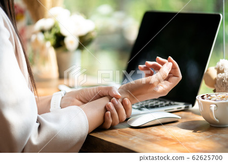 Closeup woman holding her wrist pain Closeup woman holding her wrist pain 62625700