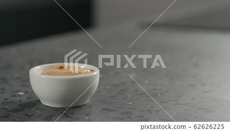 cashew paste in white bowl on terrazzo countertop cashew paste in white bowl on terrazzo countertop 62626225