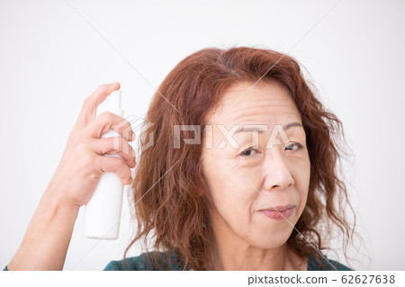 Mature woman doing hair care 62627638