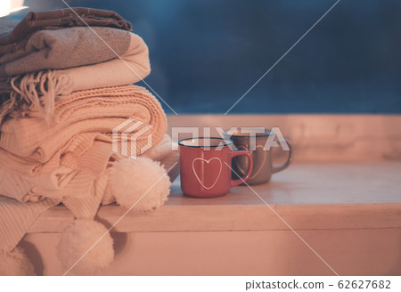 Mugs and cozy plaids on window in night Mugs and cozy plaids on window in night 62627682