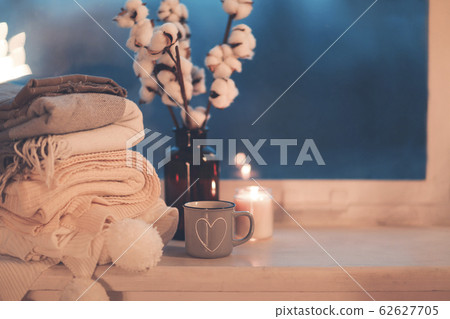 Mug and cozy plaids on window in night Mug and cozy plaids on window in night 62627705