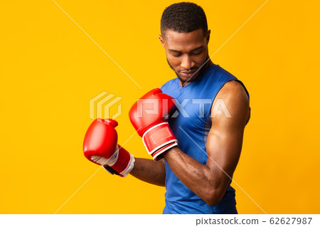 Handsome afro sports man ready for fight at orange studio 62627987