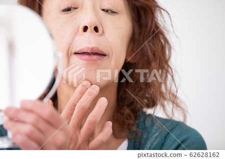 Mature woman suffering from skin trouble 62628162