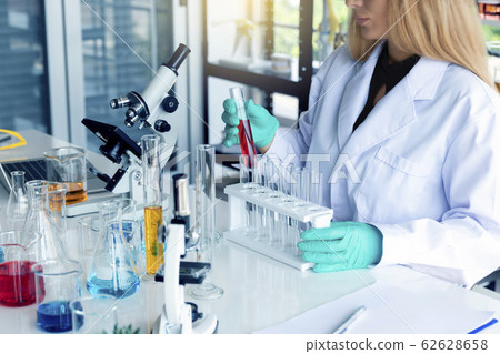Scientist working in a laboratory observing tubes. 62628658