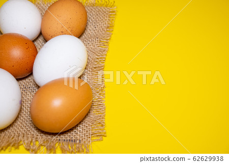 White and brown Easter eggs bright yellow background. Concept happy Easter. White and brown Easter eggs bright yellow background. Concept happy Easter. 62629938
