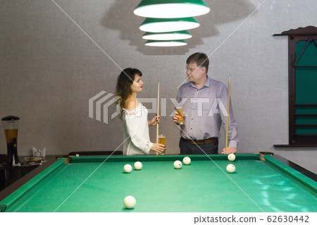 A meeting of lovers in a nightclub by billiards. 62630442