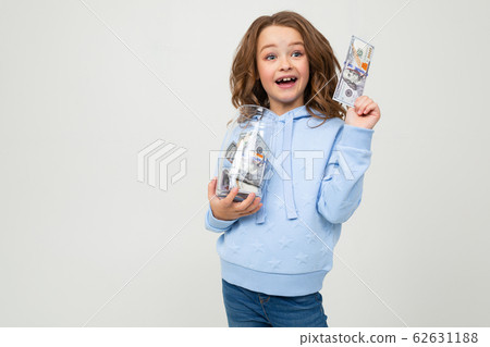 joyful cute girl with a glass jar and money on a white background with copy space. finance 62631188