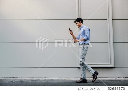 Happy Young Businessman in Casual wear Using 62633170