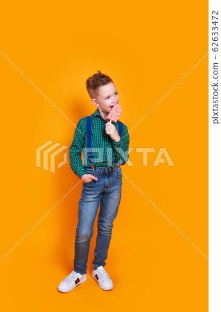 Full length photo of cute kid boy eating ice cream on yellow background 62633472