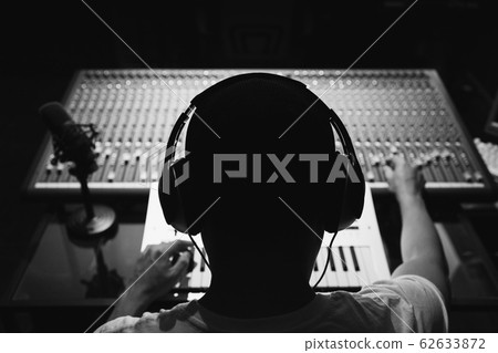 back of male sound engineer, dj working on audio mixing console in sound studio 62633872