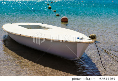 tethered boat in turquoise water with buoys tethered boat in turquoise water with buoys 62634165