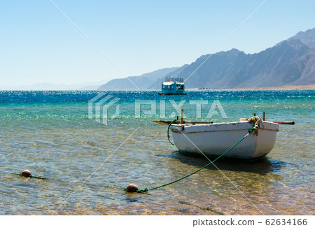 old wooden fishing boat in the sea against the backdrop of the high rocky mountains in Egypt Dahab old wooden fishing boat in the sea against the backdrop of the high rocky mountains in Egypt Dahab 62634166