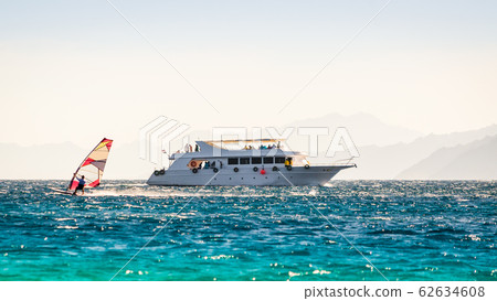 big boat and a surfer in the sea on the background of a rocky coast in Egypt Dahab 62634608