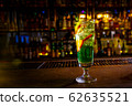 A green cocktail in a tall glass stands on the bar 62635521