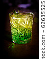 A green cocktail in an old fashion glass is on the bar 62635525