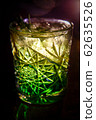 A green cocktail in an old fashion glass is on the bar 62635526