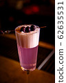 A purple Sauer cocktail in a tall glass with foam stands on the bar 62635531