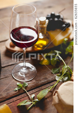 Glass of red wine with cheese and grapes 62635655
