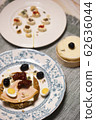 A rusk with cheese, turkey breast, quail egg, sun-dried tomato and valerianella locusta 62636044