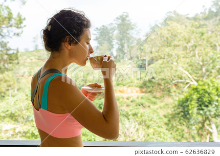 Girl drinks tea with a view of the jungle in Sri Girl drinks tea with a view of the jungle in Sri 62636829