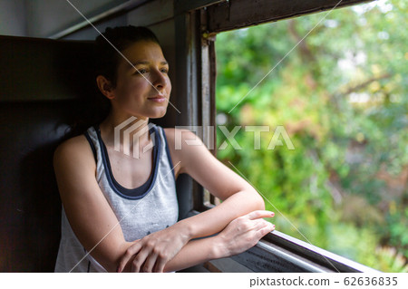 Train ride in Sri Lanka. Woman sitting and looking Train ride in Sri Lanka. Woman sitting and looking 62636835