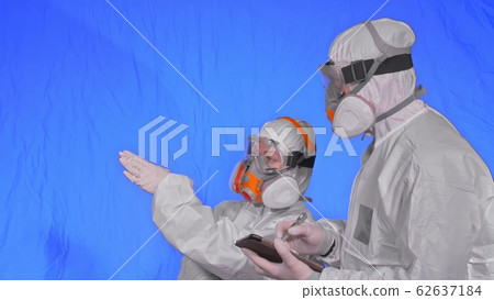 Scientist virologist in respirator makes write in an tablet computer with stylus. Man and woman wearing protective medical mask. Chroma key blue. Scientist virologist in respirator makes write in an tablet computer with stylus. Man and woman wearing protective medical mask. Chroma key blue. 62637184