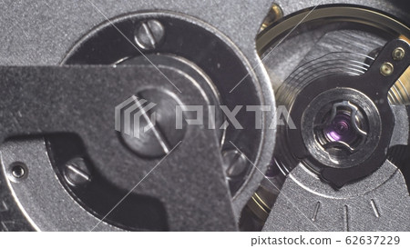 Watch mechanism macro loop. Old vintage clock mechanism working, closeup shot with soft focus. Close up of a internal clock mechanism. 62637229
