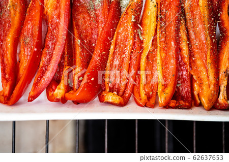 Baked red sweet bell pepper in a white ceramic baking dish. Flat lay. Copy space 62637653