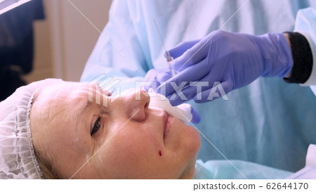 Woman getting cosmetic injection, closeup. Woman in beauty salon. plastic surgery clinic Woman getting cosmetic injection, closeup. Woman in beauty salon. plastic surgery clinic 62644170