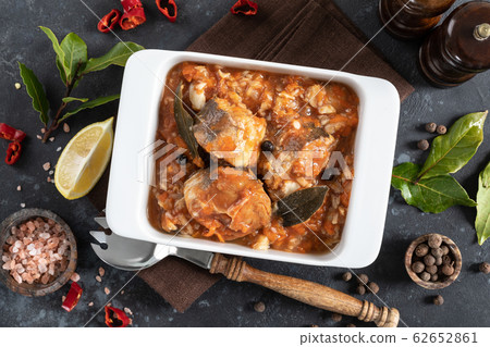 Hake fish, cooked in tomato sauce with vegetables Hake fish, cooked in tomato sauce with vegetables 62652861