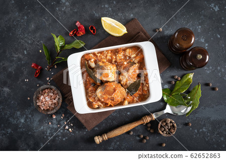 Hake fish, cooked in tomato sauce with vegetables Hake fish, cooked in tomato sauce with vegetables 62652863