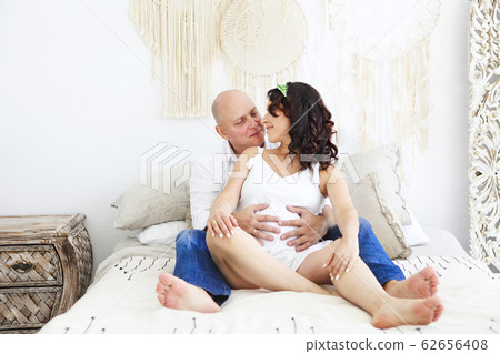 Man and pregnant woman on bed Man and pregnant woman on bed 62656408