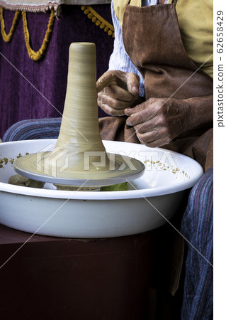 hands of a potter creating a piece of clay 62658429