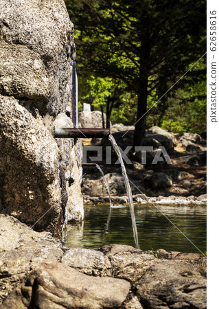 stream of fresh water coming out of a metal spout stream of fresh water coming out of a metal spout 62658616