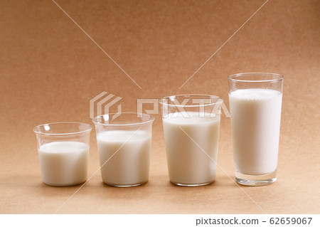 glasses of milk arranged as increasing height. glasses of milk arranged as increasing height. 62659067