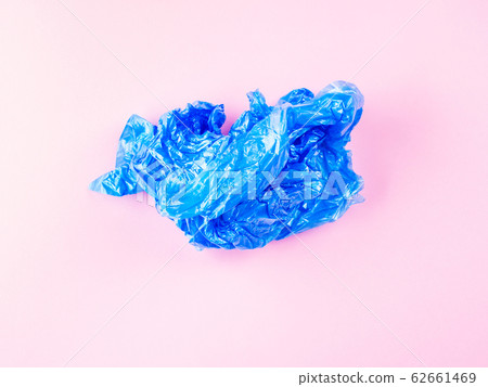 Crumpled blue plastic trash bag on pink background Crumpled blue plastic trash bag on pink background 62661469