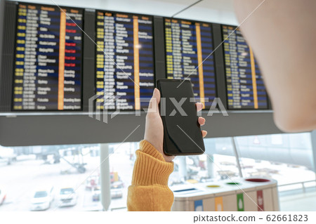 Young woman checking flight on timetable Young woman checking flight on timetable 62661823