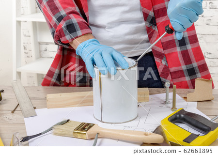 house painter opens a can of paint with a 62661895