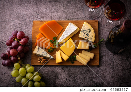 Assorted cheeses of various types and red wine Assorted cheeses of various types and red wine 62663317