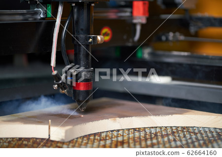 Computer cnc machine prent on wooden board in workshop 62664160